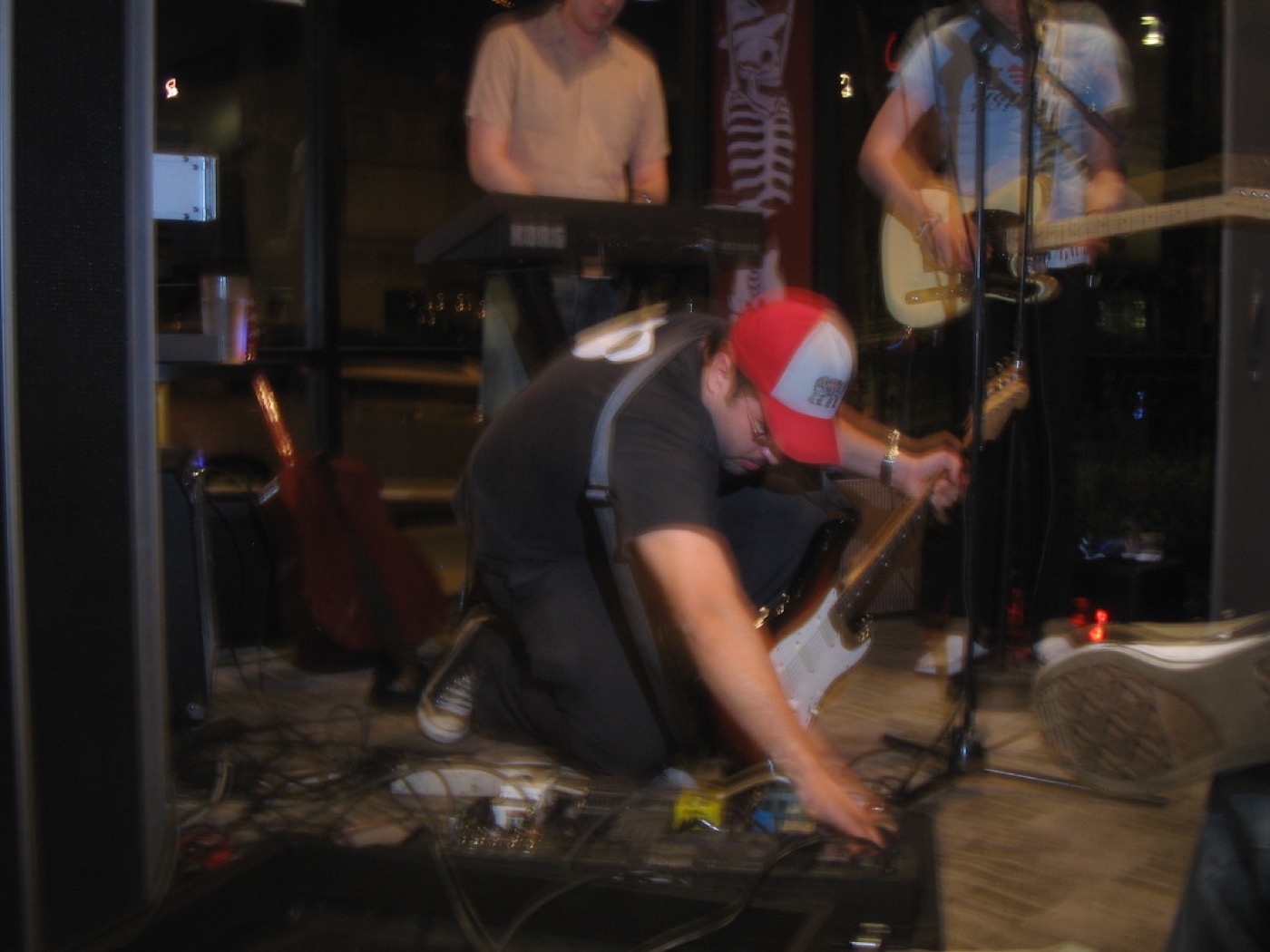 Eddie Garcia adjusting guitar pedals onstage with Family Sedan.