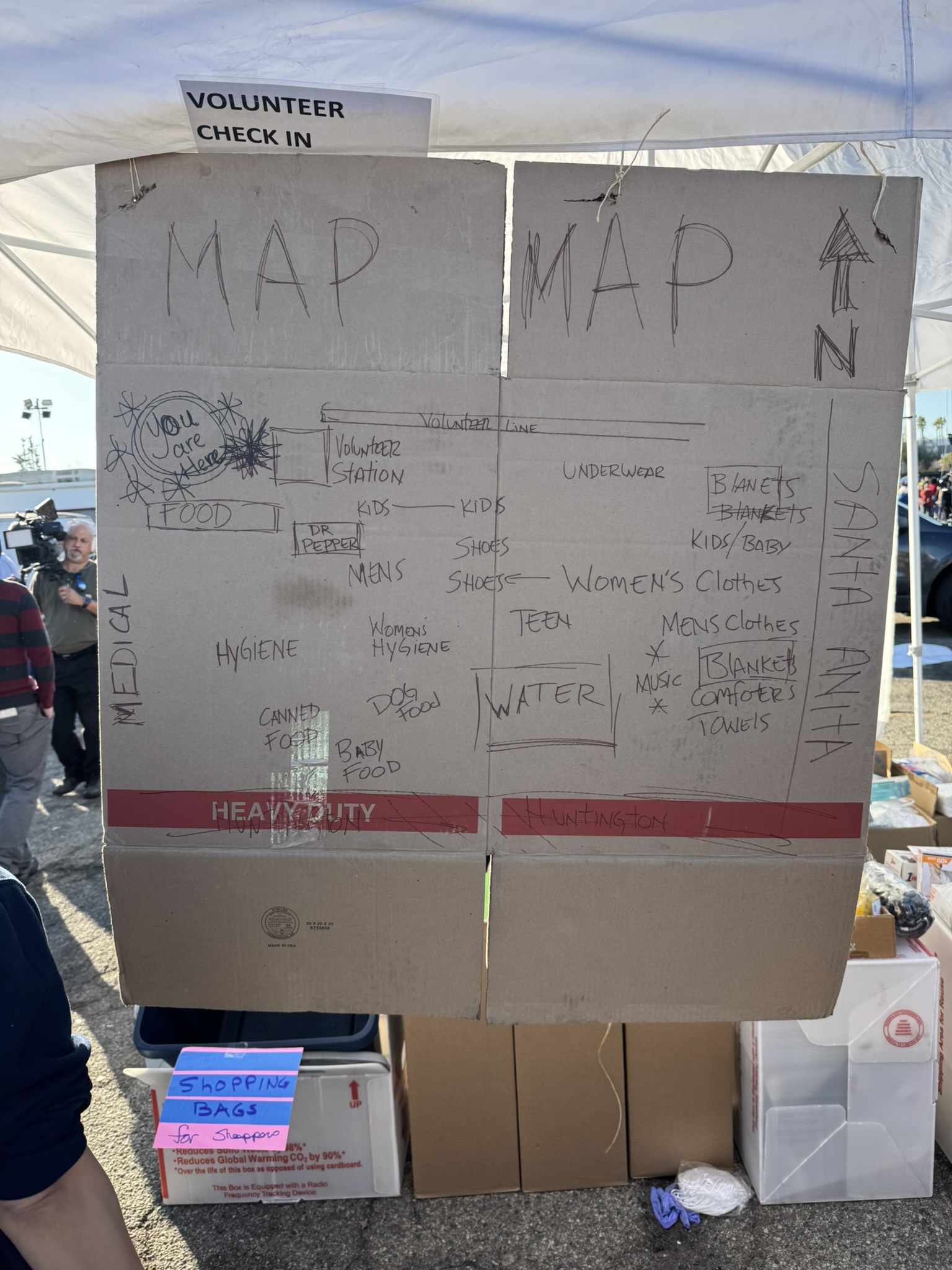 A handmade cardboard map showing volunteer check-in and supply zones at Santa Anita.