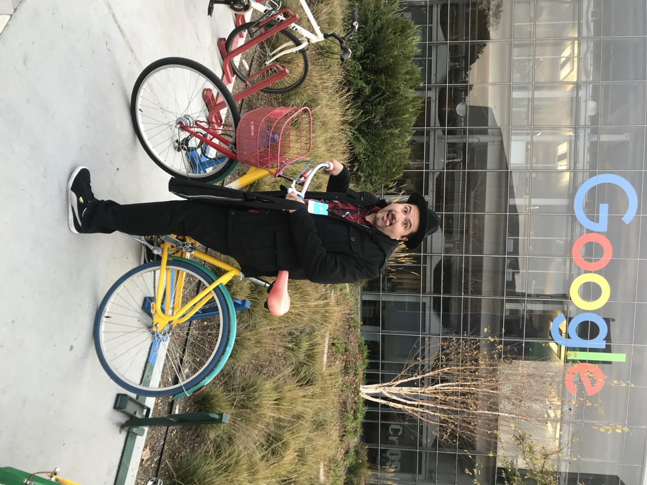 Eddie Garcia standing beside colorful Google bikes outside a Google campus.